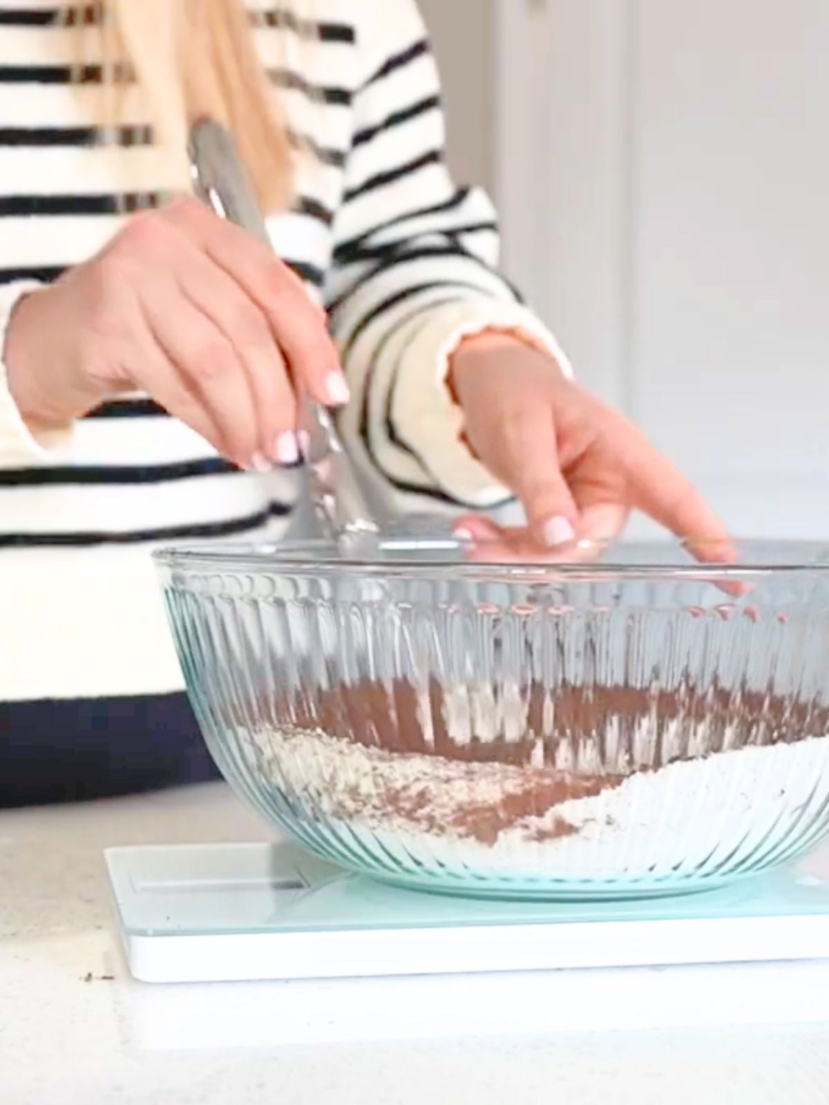 A woman whisking dry ingredients.