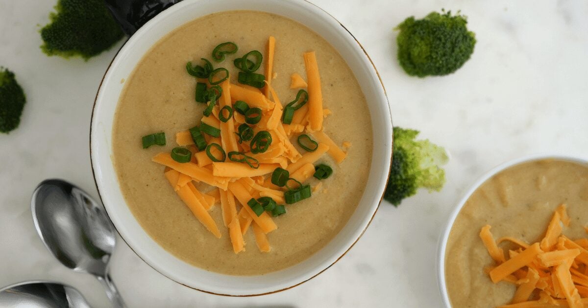 Broccoli cheese soup topped with shredded cheddar and green onions