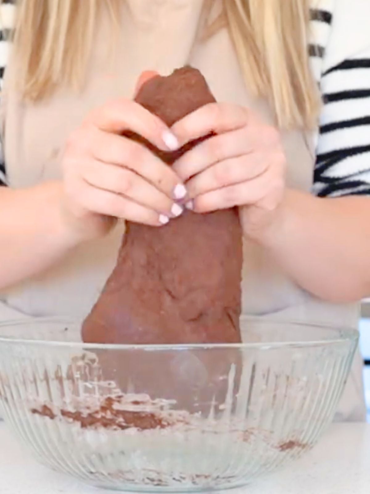Hands stretching chocolate dough.
