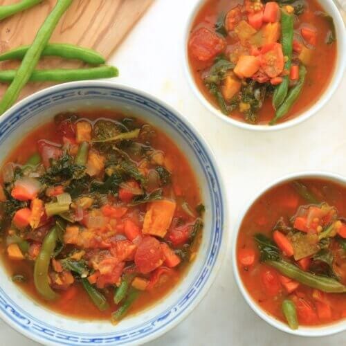Multiple bowls of fire-roasted tomato and vegetable soup served on a table