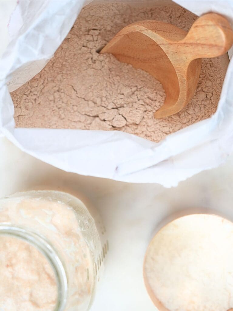A bag of starter and flour on a counter.