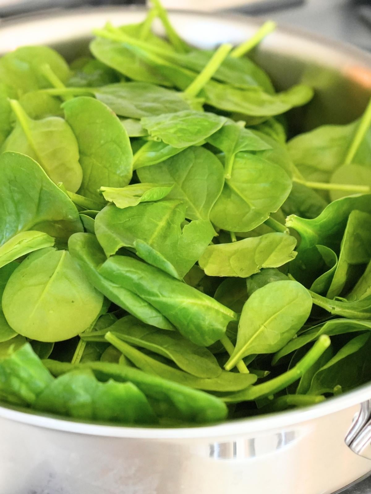 Fresh spinach in a skillet.