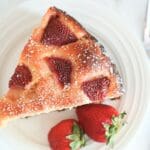 Sourdough strawberry cake slice on a plate next to a fork.