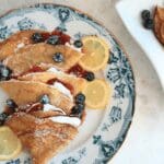Sourdough crepes on decorative plate with blueberries and lemons