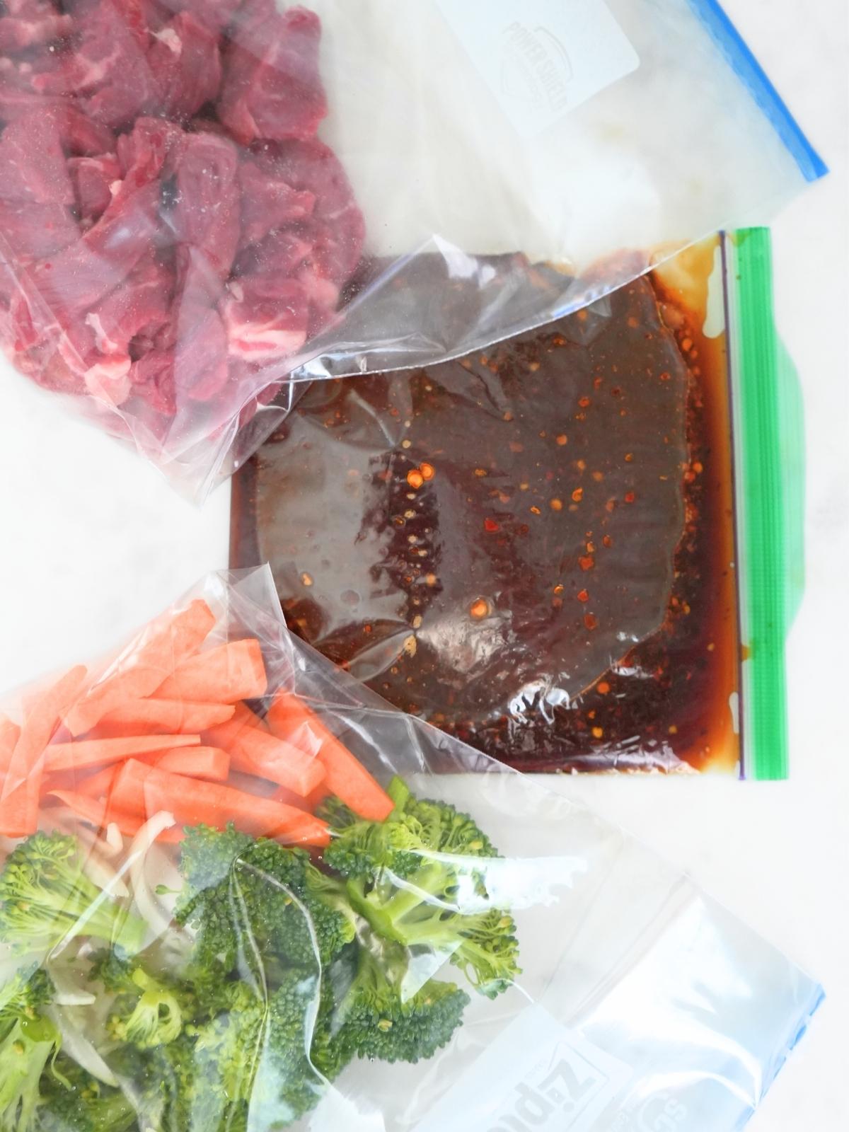 Steak, veggies, and sauce in separate bags.