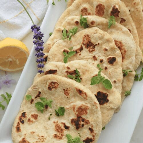 Platter of sourdough flatbread with lemons and herbs
