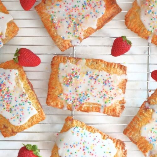 Strawberry sourdough Pop Tarts and fresh berries on a cooling rack.