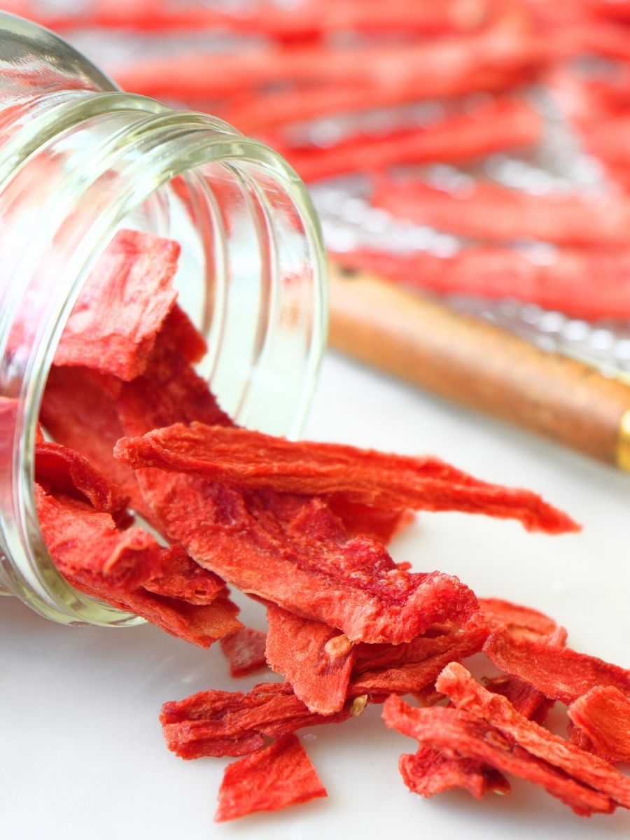 Dehydrated watermelon spilling out of a glass mason jar
