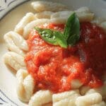 Homemade pasta topped with marina sauce and fresh basil