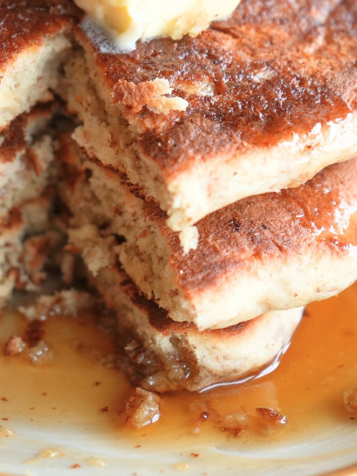 Molasses syrup puddled on a plate of pancakes.