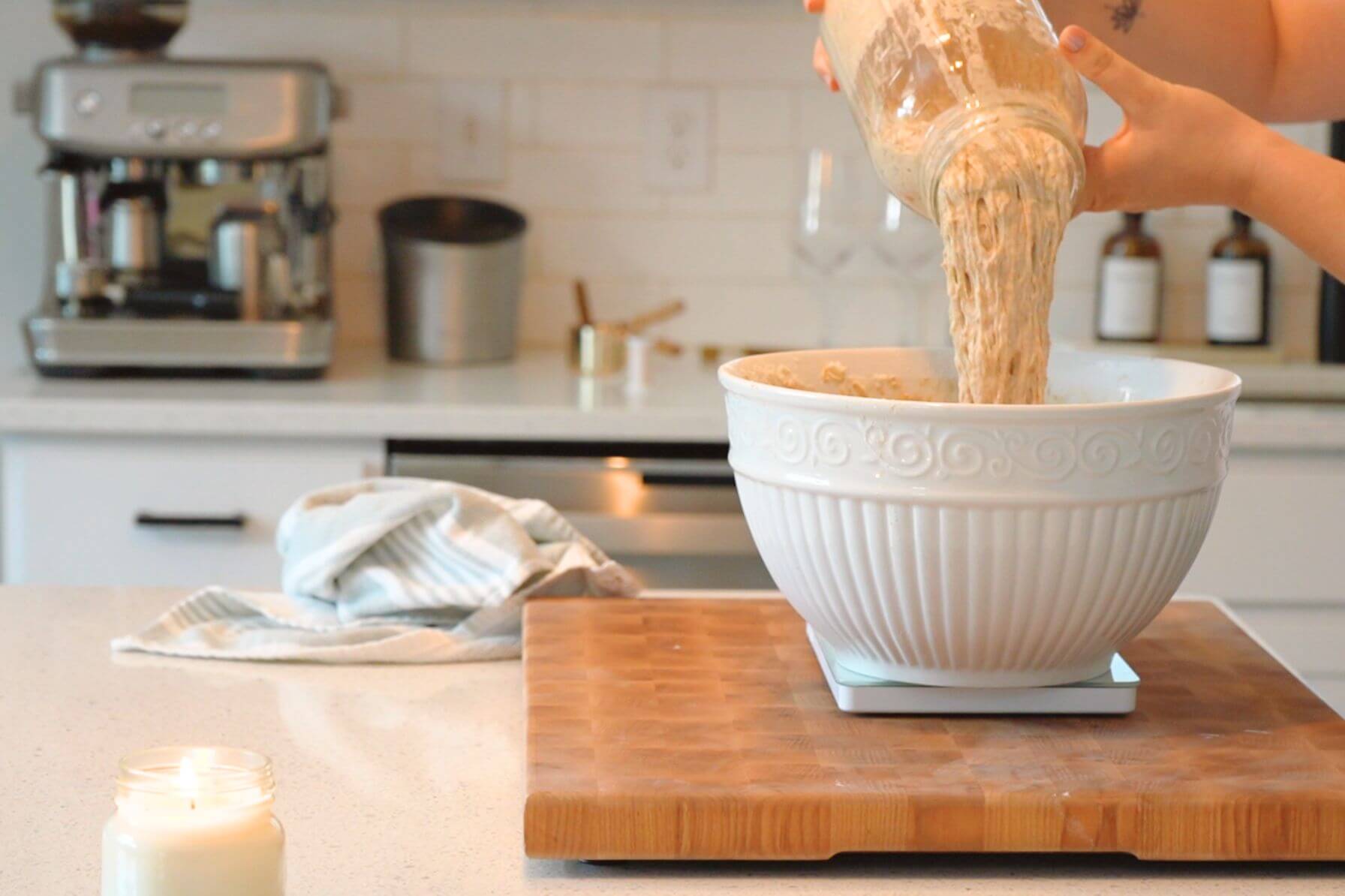 Rebecca pouring sourdough starter into large bowl