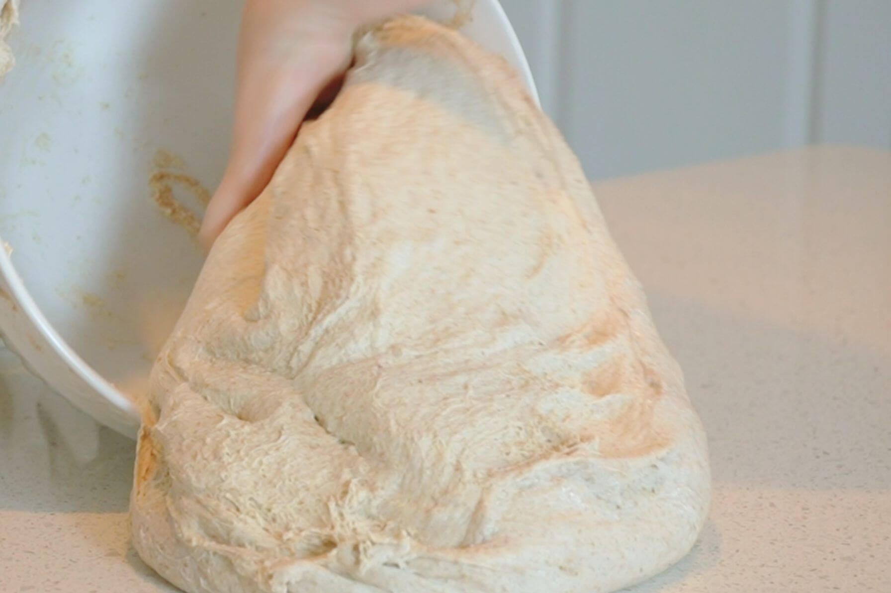 Dough falling out of bowl onto a countertop