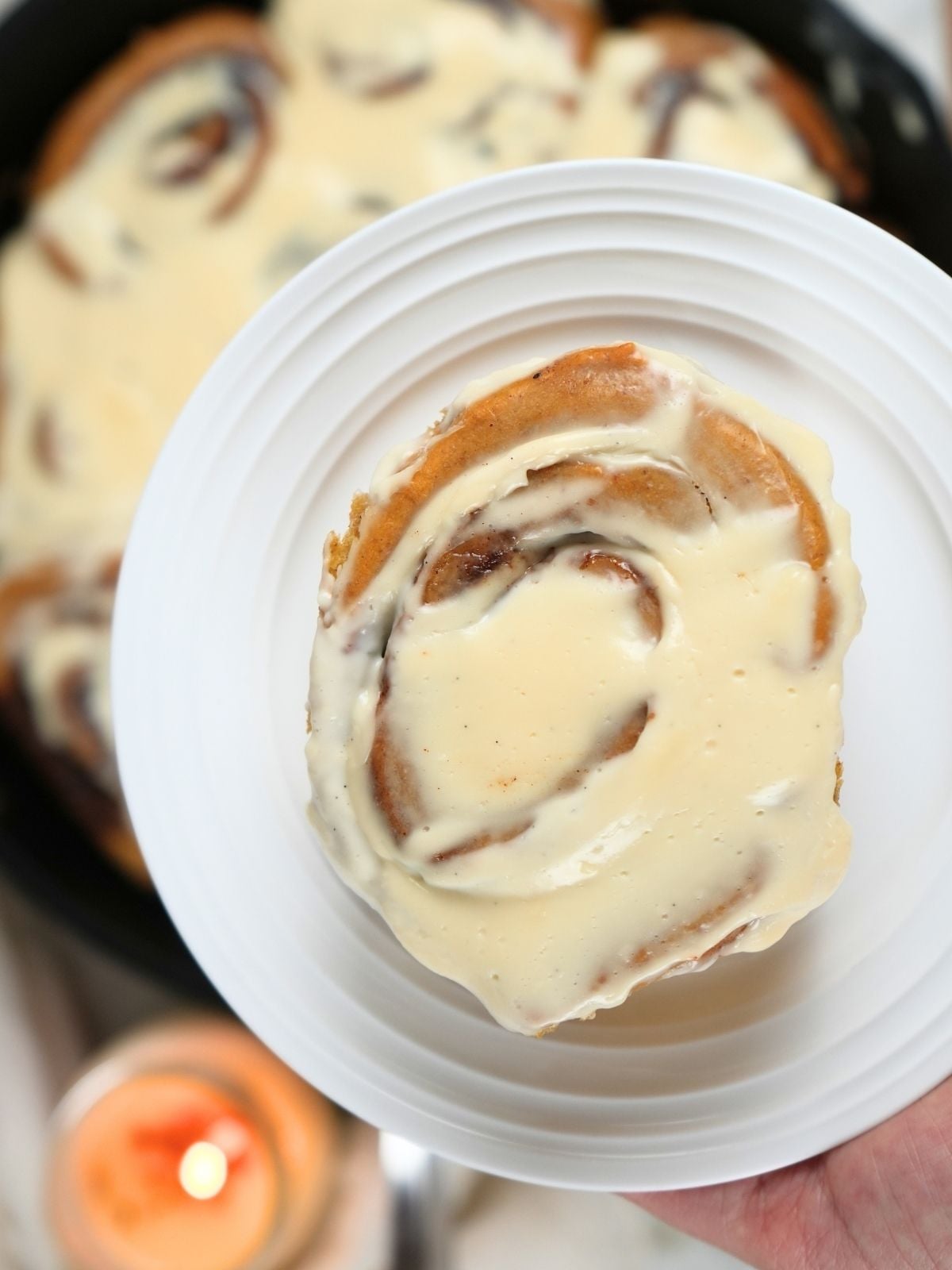 A sourdough pumpkin cinnamon roll on a plate.