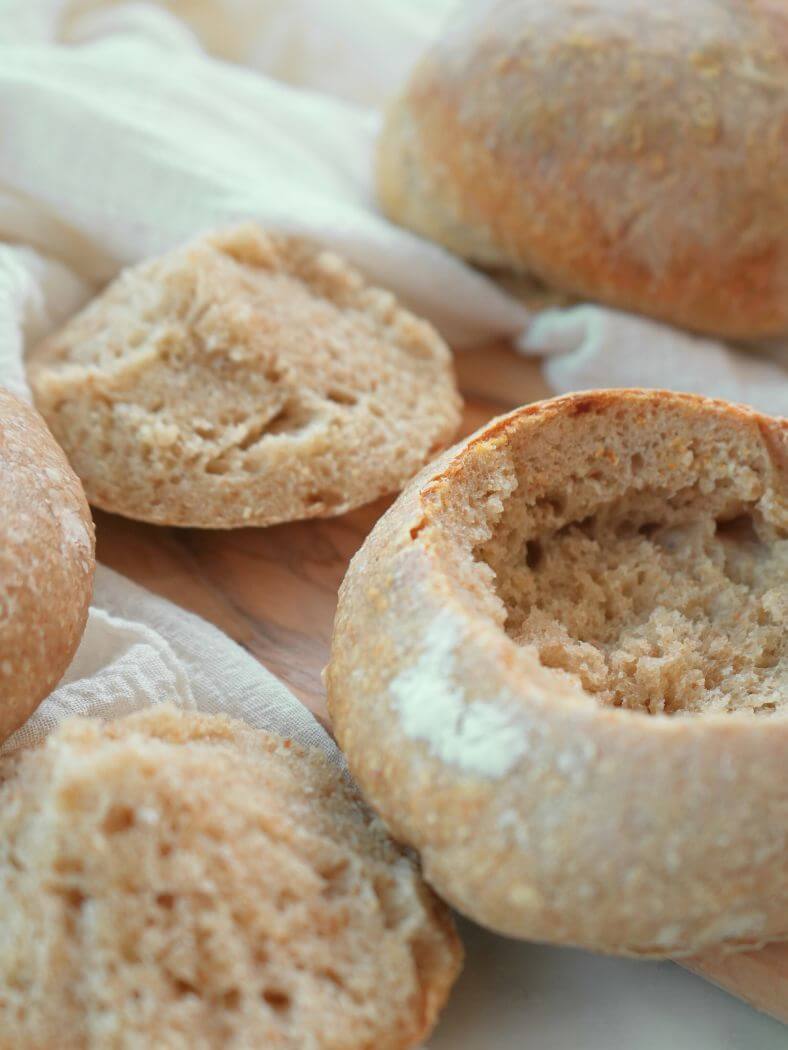 Hollowed sourdough bread bowl shown next to the removed filling and top