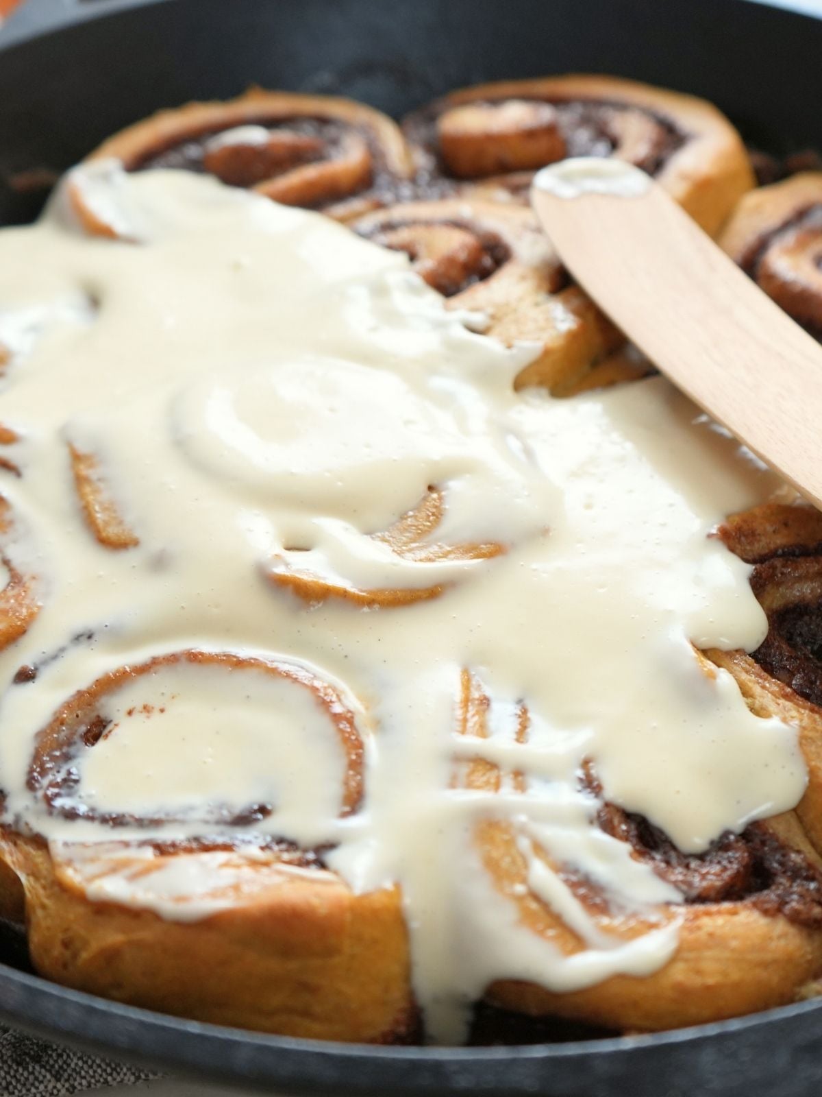 Sourdough pumpkin cinnamon rolls in a cast iron skillet.