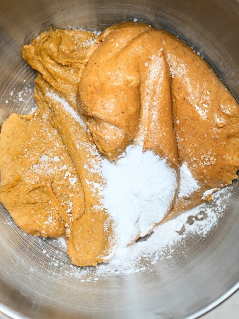 Dough with baking soda and baking powder sprinkled on top.