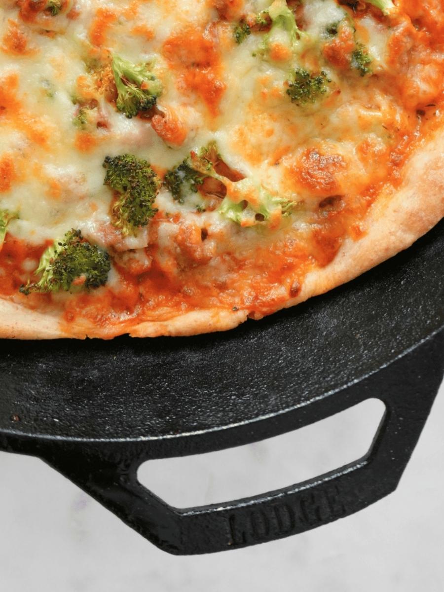 Close up of pizza made with sourdough pizza dough in a cast iron skillet