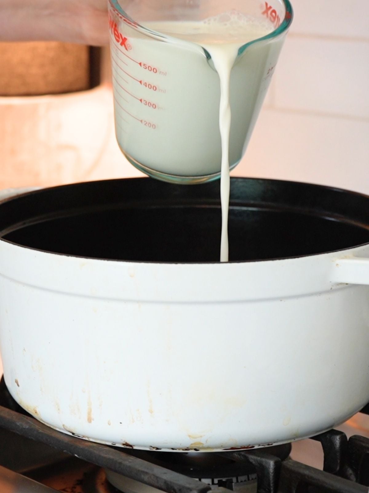Milk pouring into a cast iron Dutch oven.