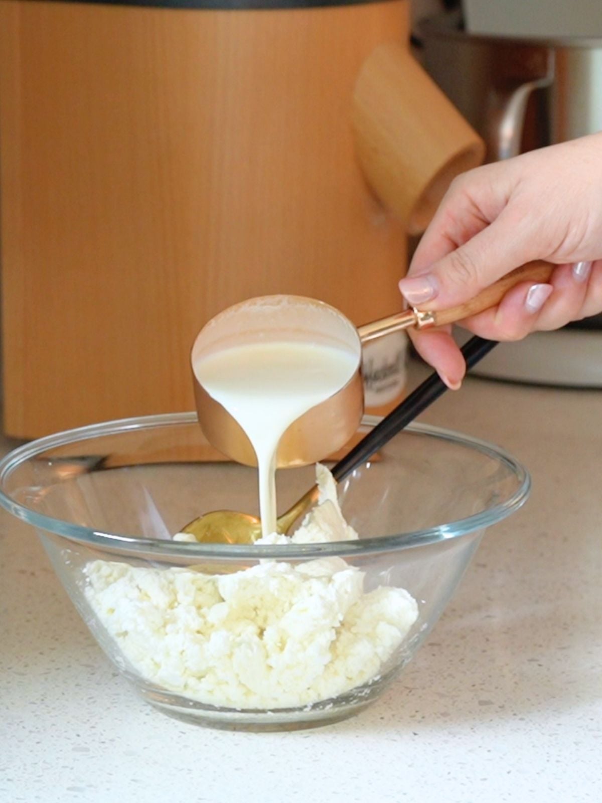 Heavy cream being poured over cheese curds.