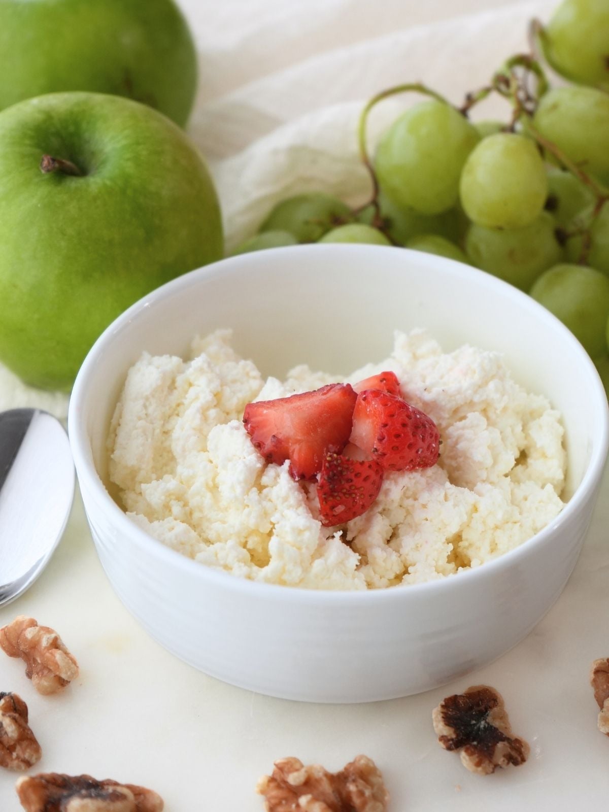 Homemade cottage cheese surrounded by fresh fruit.