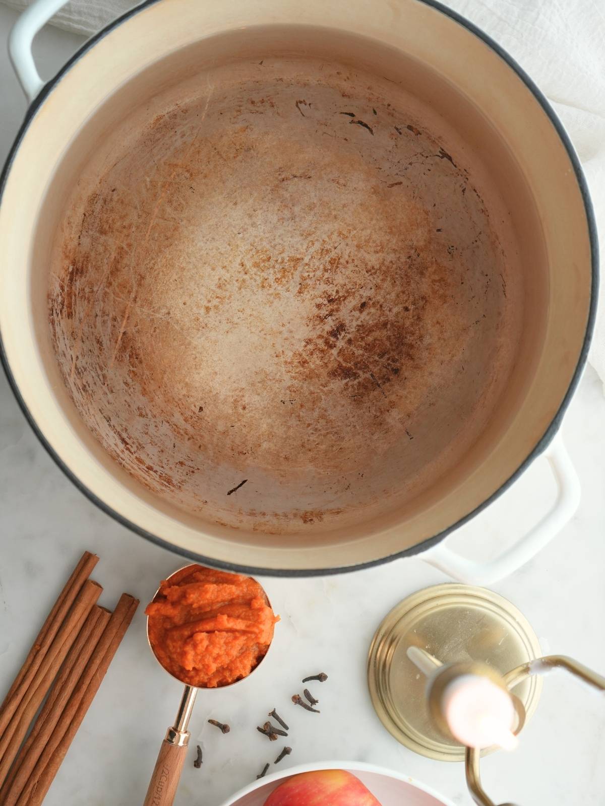 A Dutch oven and simmer pot ingredients on a counter.