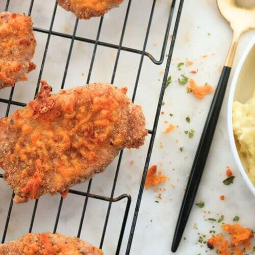 Sourdough crispy cheddar pork chops on a cooling rack, paired with creamy mashed potatoes