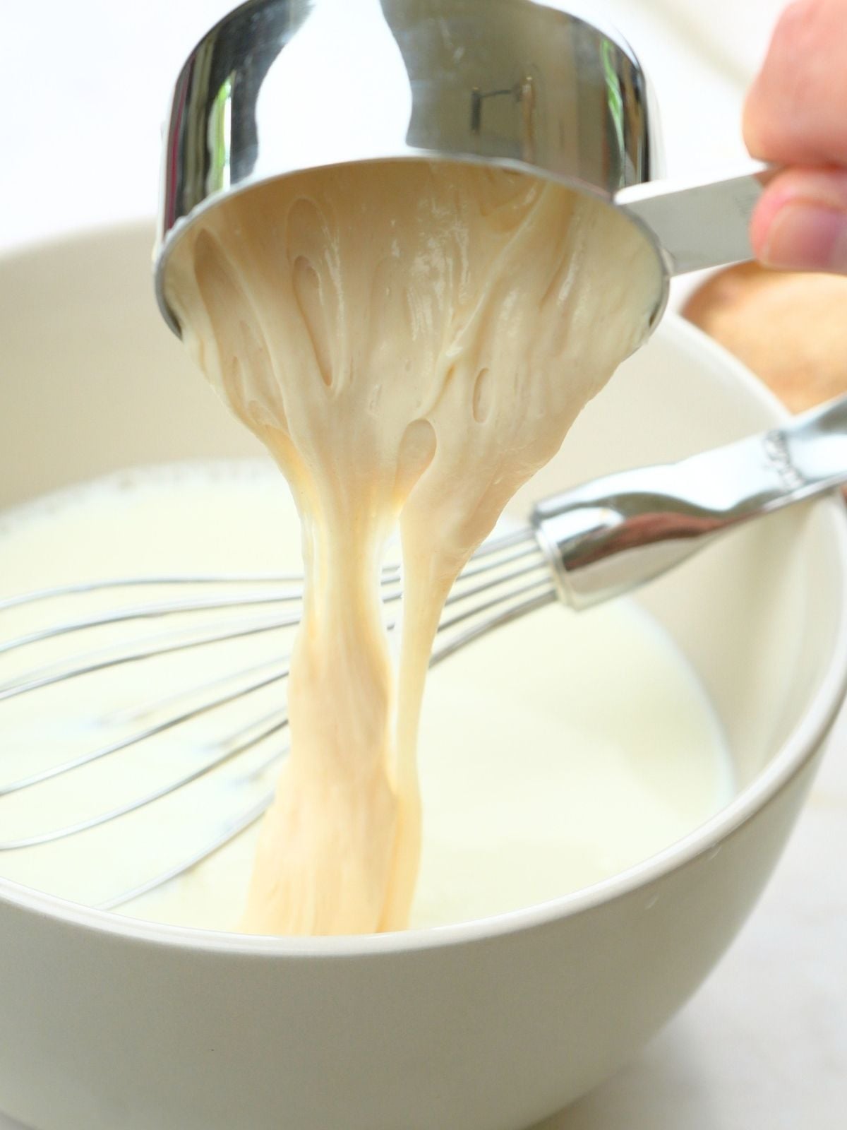 Sourdough discard pouring into a bowl.