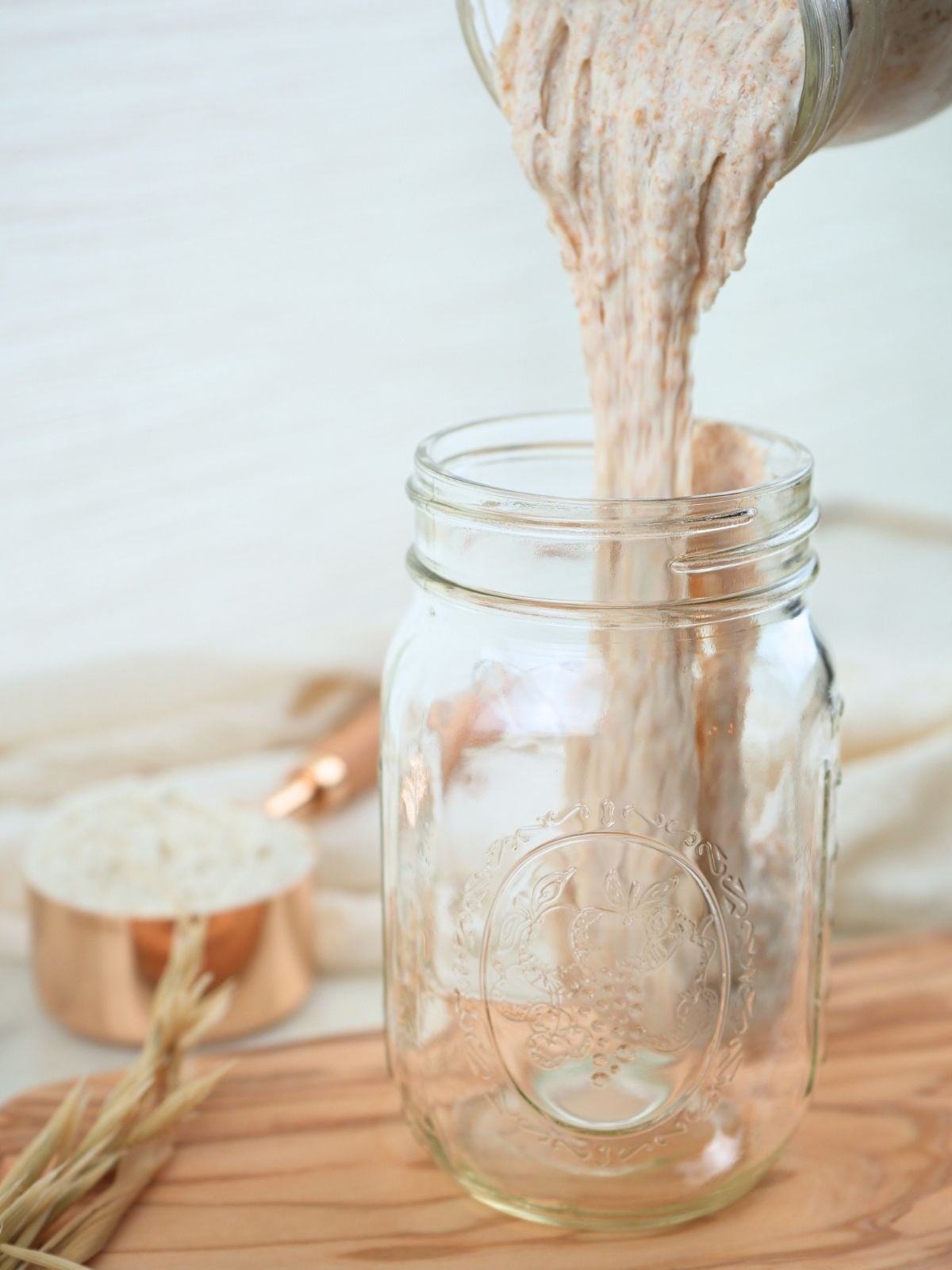 Sourdough discard being poured into a jar.