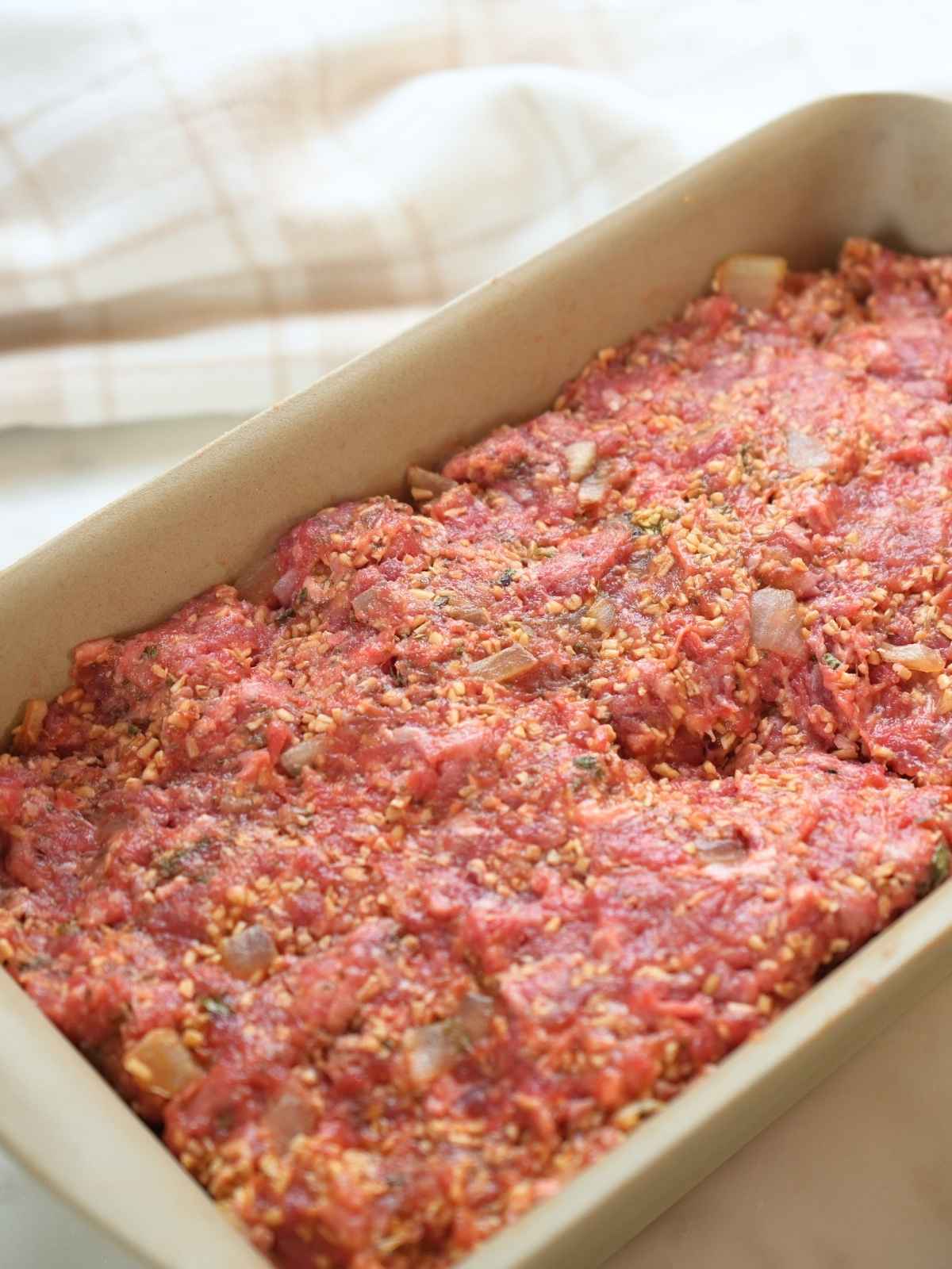 Meatloaf mixture in a loaf pan.