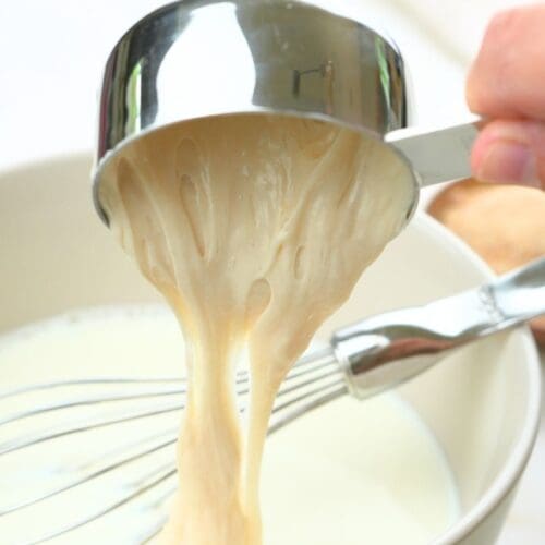 Sourdough stater discard being poured into a bowl of milk.