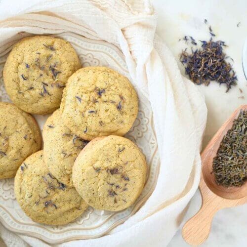 A plate of sourdough London Fog cookies topped with dried cornflowers.