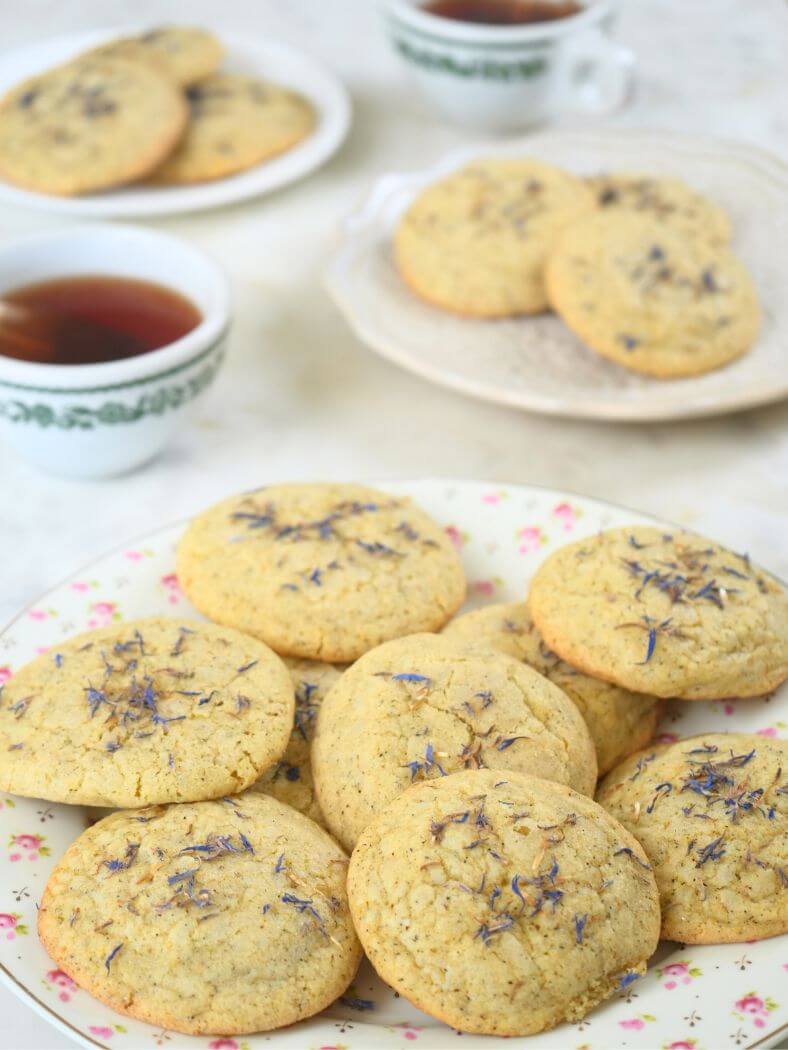 Plates of sourdough London Fog cookies surrounded by cups of tea.