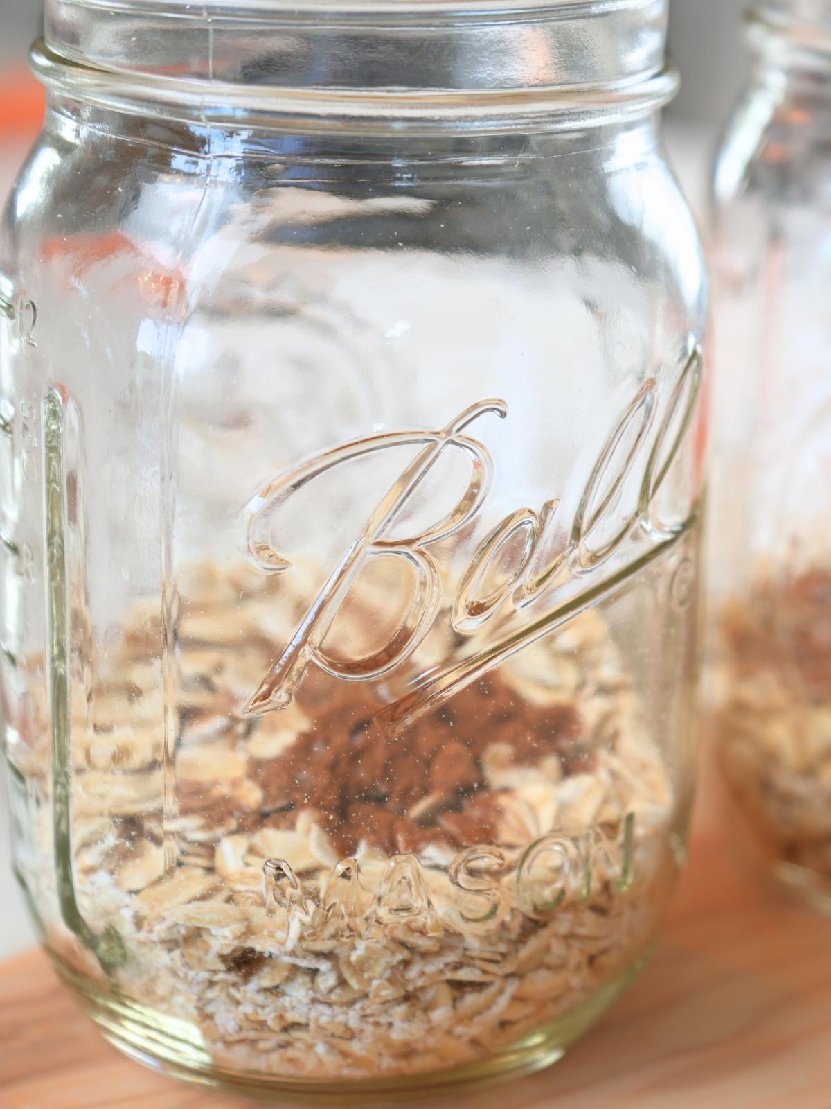 A mason jar filled with oats and dry ingredients.