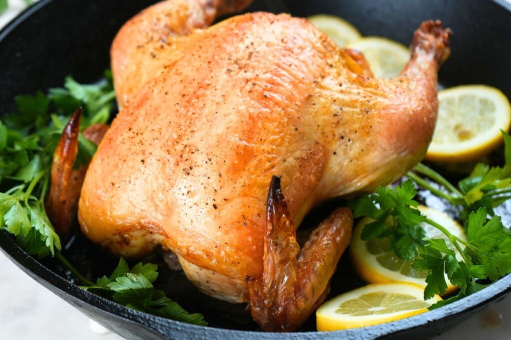 Golden brown roast chicken in a cast-iron skillet