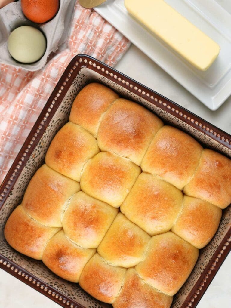 Baked sourdough brioche rolls with, displayed with butter and eggs.