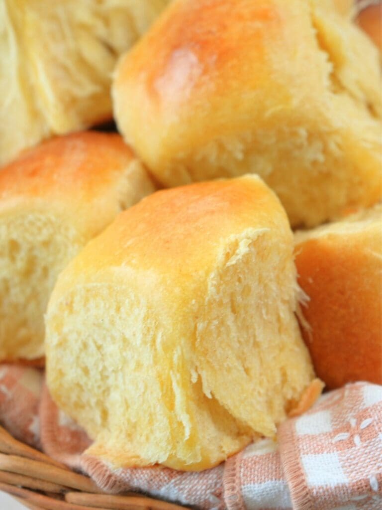 Pull-apart rolls in a piled in a basket for serving.