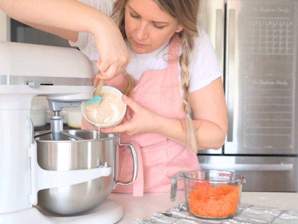 Woman pouring sourdough starter into a stand mixer.