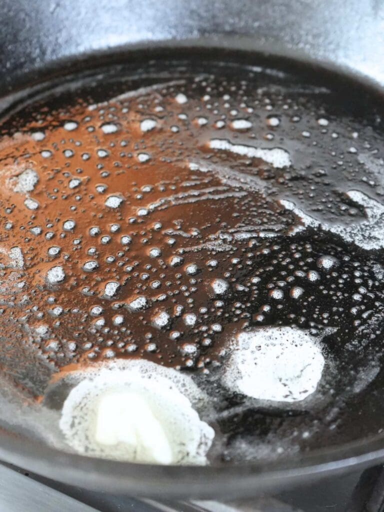 Butter melting in a cast iron skillet.