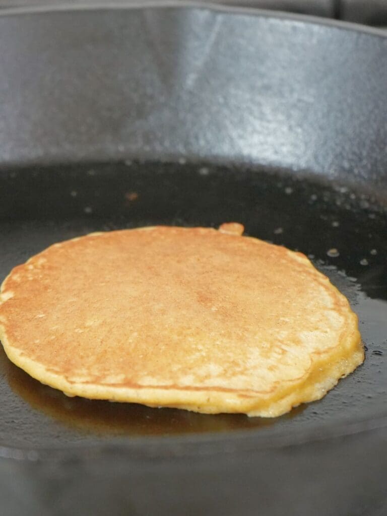 Sourdough discard pancake cooking on second side.