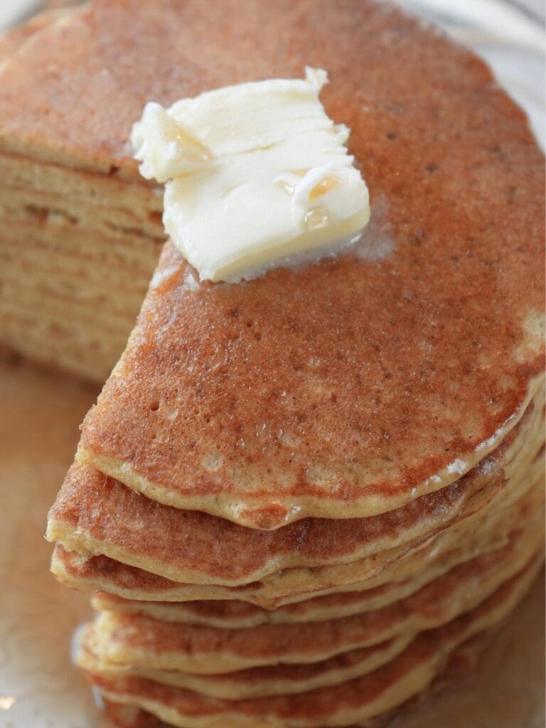 A stack of sourdough discard pancakes with butter on top.