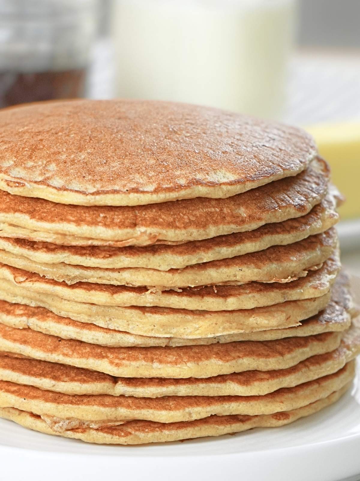 Stack of sourdough discard pancakes with butter and milk in the background.