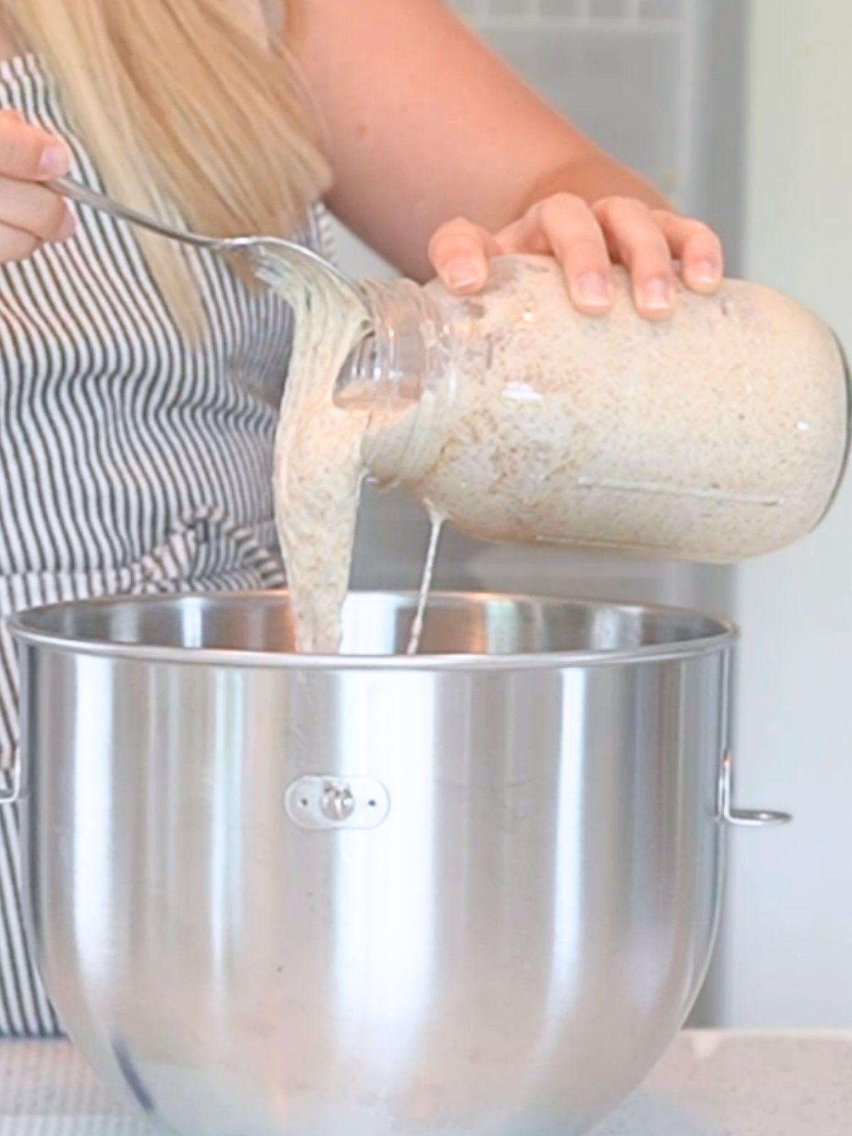 Woman pouring starting into mixing bowl.