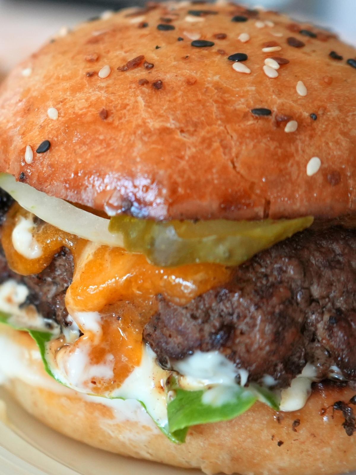 A cheeseburger on a sourdough burger bun.