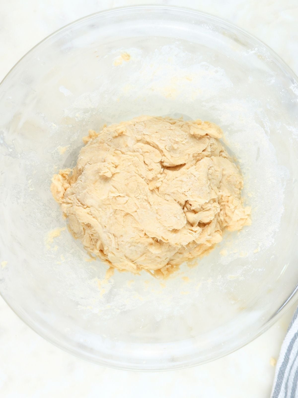 A ball of sourdough tortilla dough in a glass bowl.