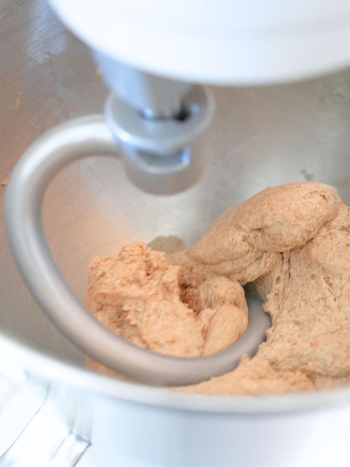 A dough hook attachment on a stand mixer kneading dough