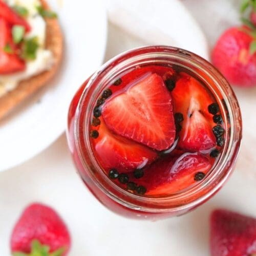 Pickled strawberries in a glass jar.