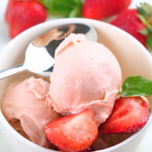 A small bowl of homemade strawberry ice cream and fresh berries.
