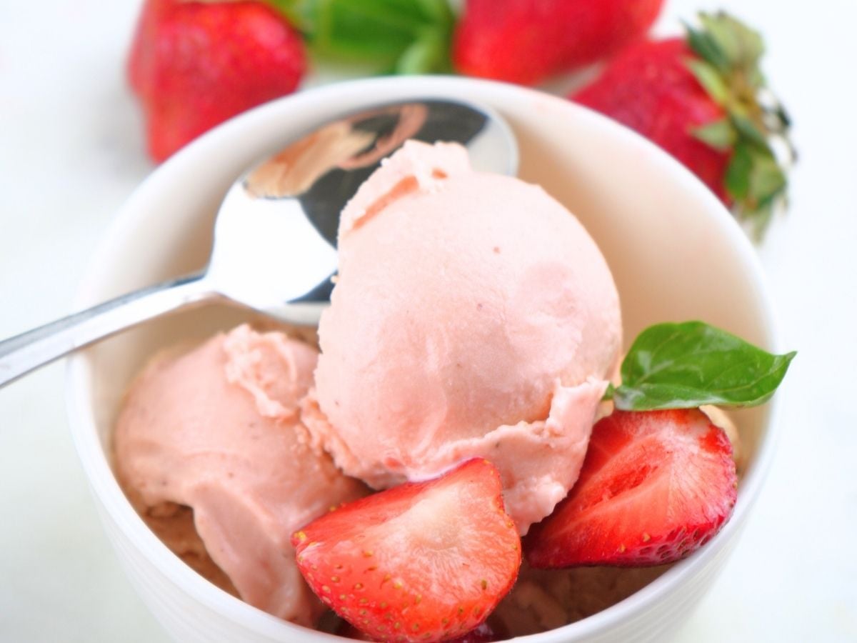 A small bowl of homemade strawberry ice cream and fresh berries.