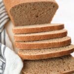 Slices of fresh-milled sourdough sandwich bread with a loaf in the background.