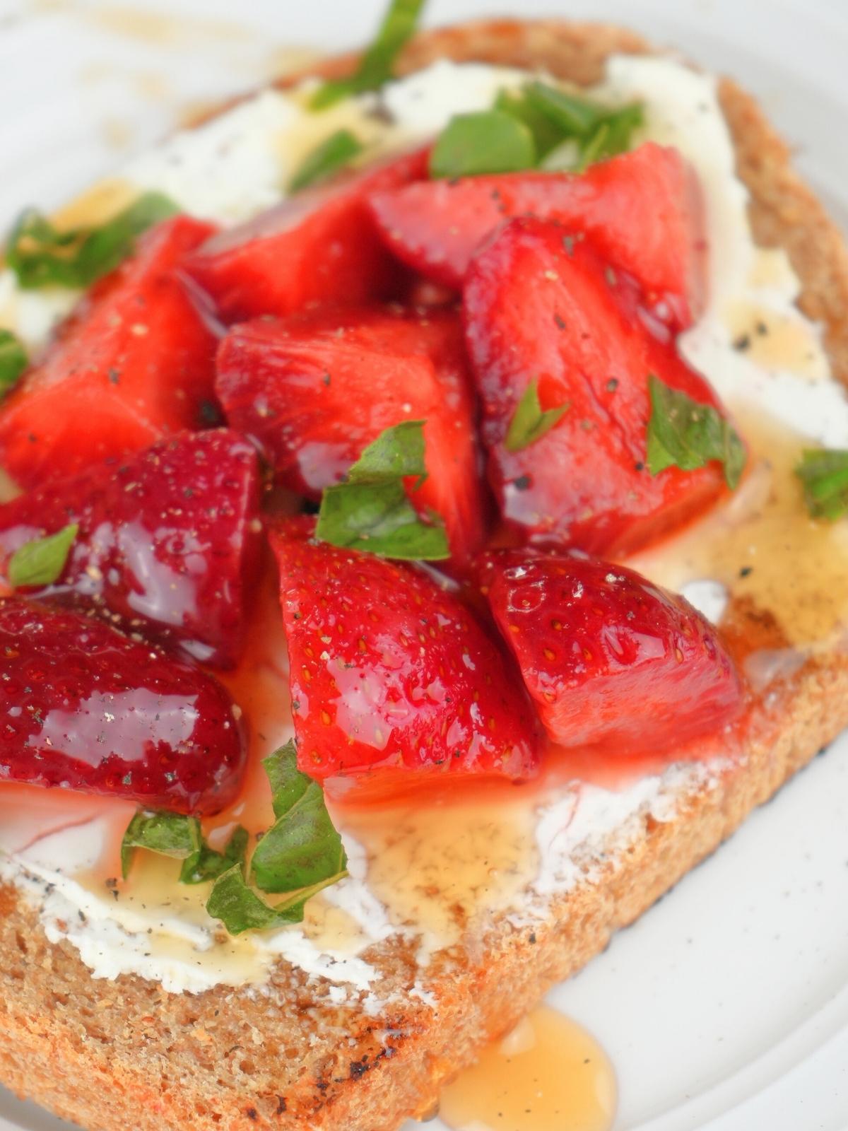 Toast with cream cheese, pickled strawberries, fresh basil, and honey
